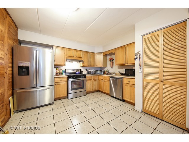 214 East Bailey Road, Unit A Naperville, IL 60565 - Photo 4 of 10 a kitchen with a refrigerator a stove top oven and cabinets
