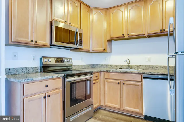 a kitchen with stainless steel appliances granite countertop a sink and a stove