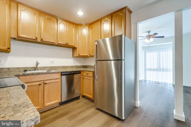 a kitchen with a refrigerator sink and cabinets
