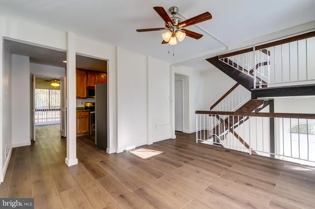 a view of an entryway with wooden floor stairs and a livingroom view