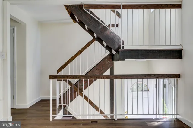 a view of staircase with railing and white walls