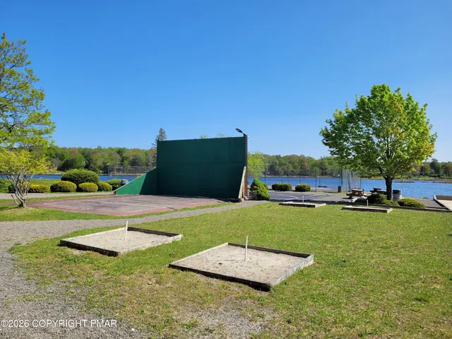 a view of a big yard with potted plants and large trees