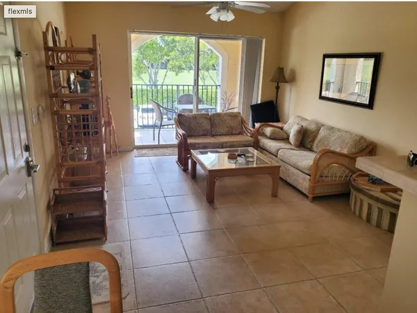 a living room with furniture a flat screen tv and a large window