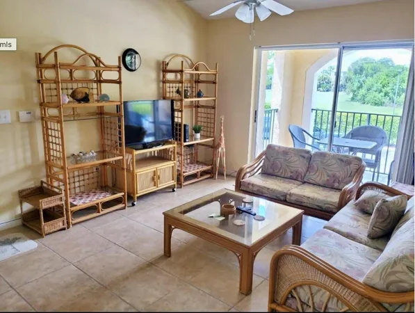 a living room with furniture a flat screen tv and a large window