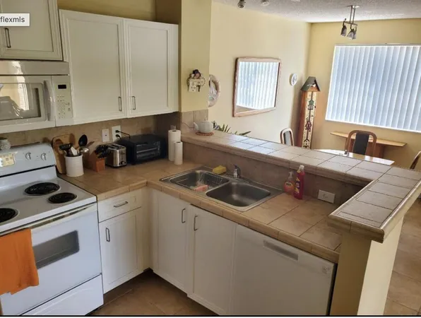 a kitchen with appliances a sink and cabinets