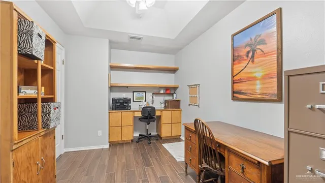 a view of a workspace with furniture and a window