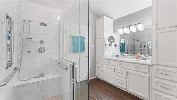 a bathroom with a double vanity sink toilet and shower