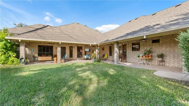 a view of a house with backyard and a tree