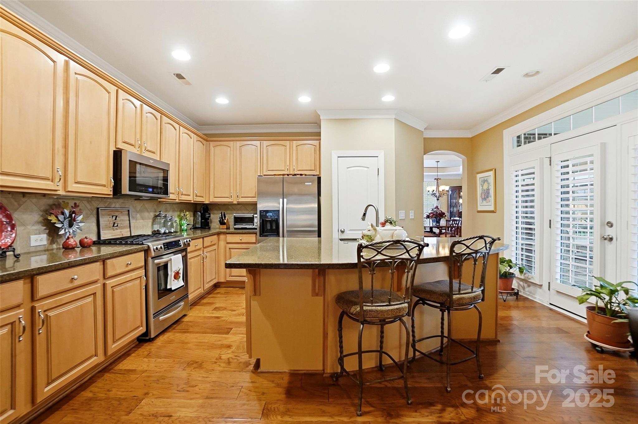 7200 Firespike Road Charlotte, NC 28277 - Photo 14 of 48 a kitchen with stainless steel appliances granite countertop a stove top oven a sink a dining table and chairs with wooden floor
