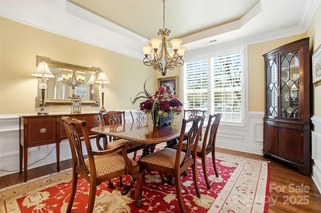 a dining room with furniture a chandelier and wooden floor