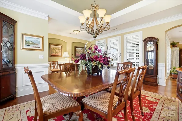 a view of a dining room with furniture a chandelier and wooden floor