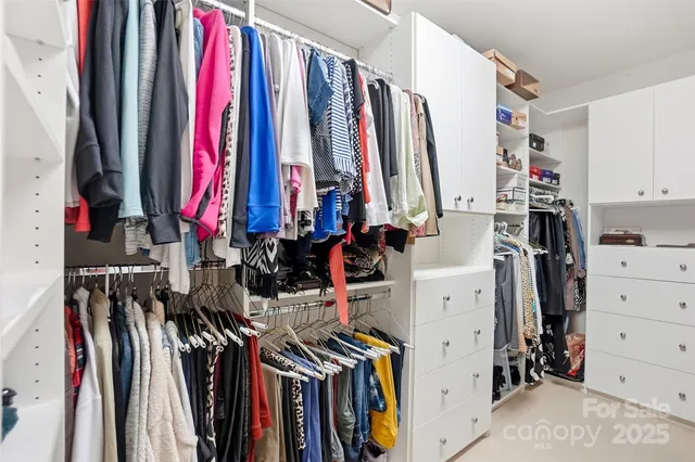 a view of walk in closet with clothes