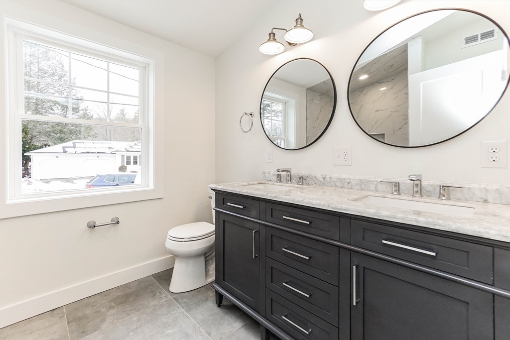 40 Great Road Maynard, MA 01754 - Photo 15 of 30 a bathroom with a granite countertop toilet a sink and a mirror