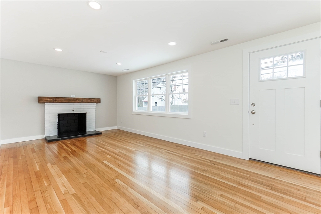 40 Great Road Maynard, MA 01754 - Photo 2 of 30 a view of an empty room with wooden floor and a window