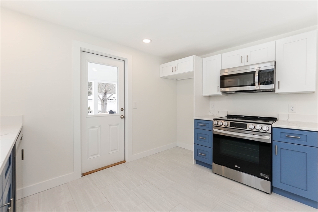 40 Great Road Maynard, MA 01754 - Photo 8 of 30 a kitchen with stainless steel appliances granite countertop white cabinets a stove top oven