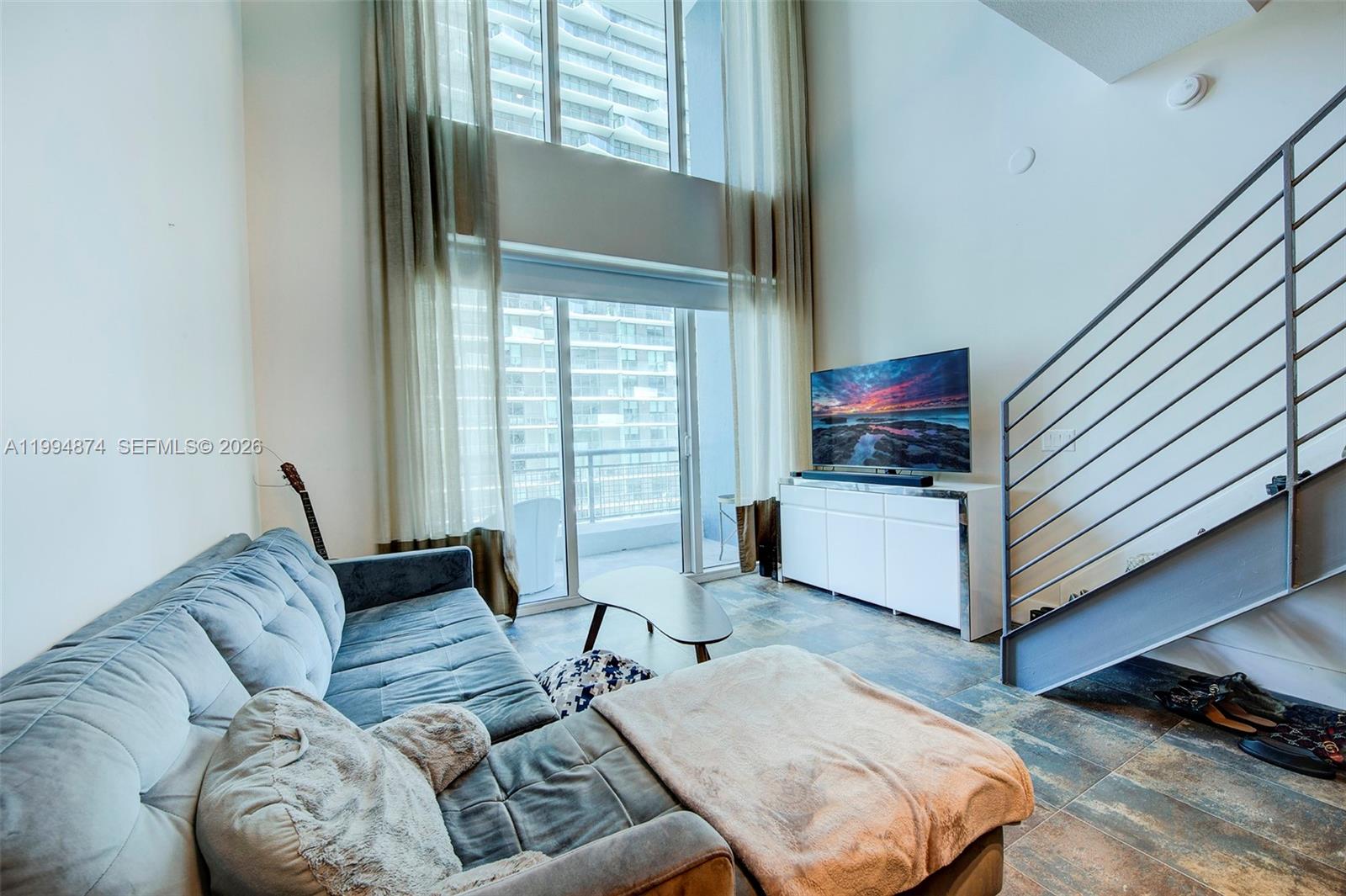 60 Southwest 13th Street, Unit 2820 Miami, FL 33130 - Photo 2 of 25 a living room with furniture and a window