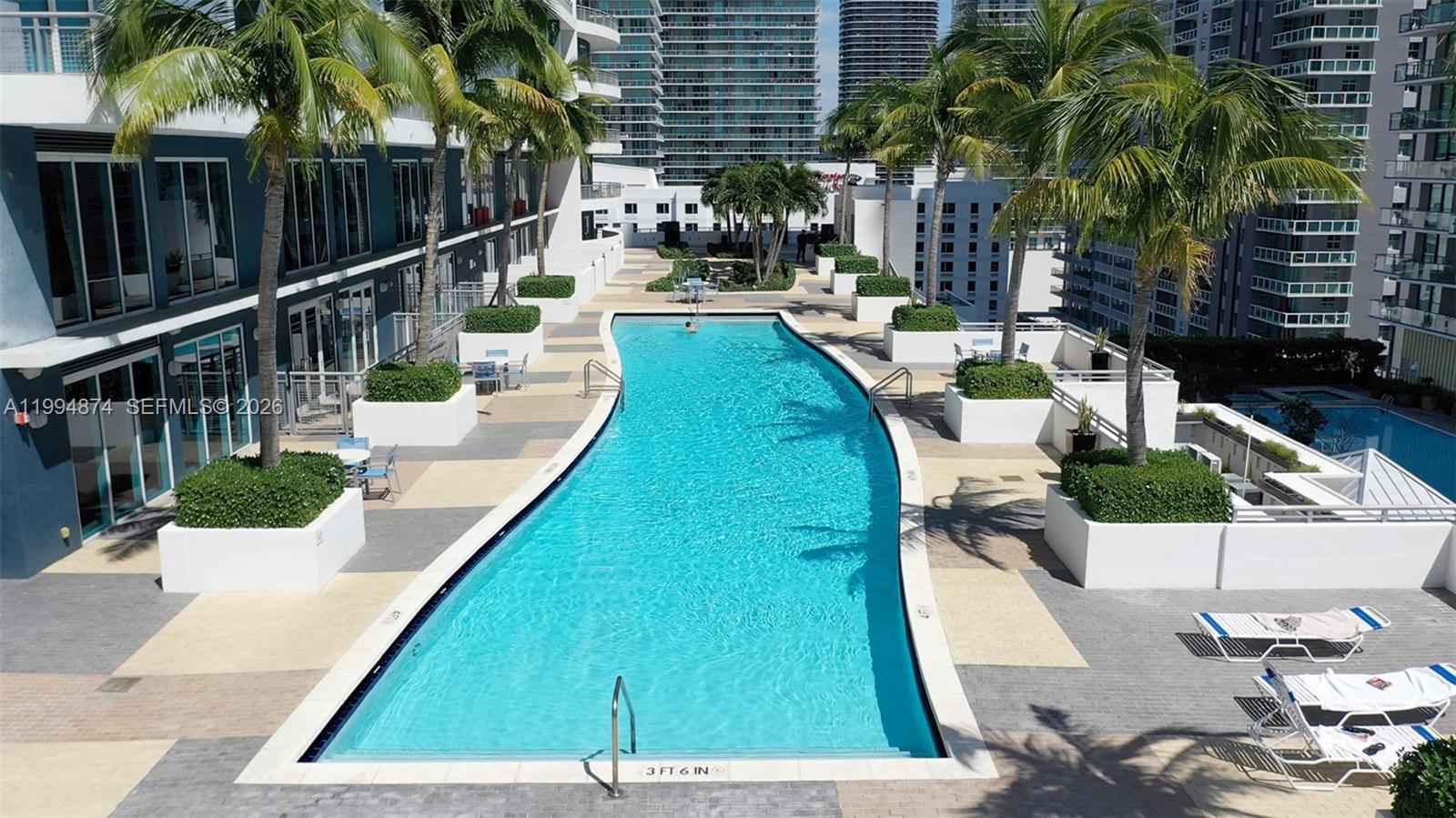 60 Southwest 13th Street, Unit 2820 Miami, FL 33130 - Photo 23 of 25 a view of a swimming pool with a patio and plants