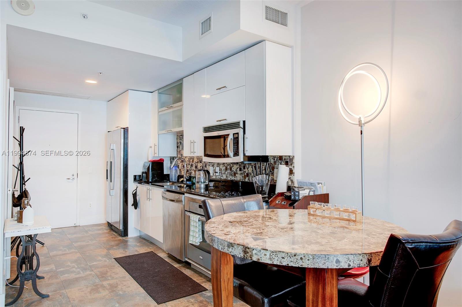 60 Southwest 13th Street, Unit 2820 Miami, FL 33130 - Photo 4 of 25 a kitchen with stainless steel appliances granite countertop a sink stove and refrigerator