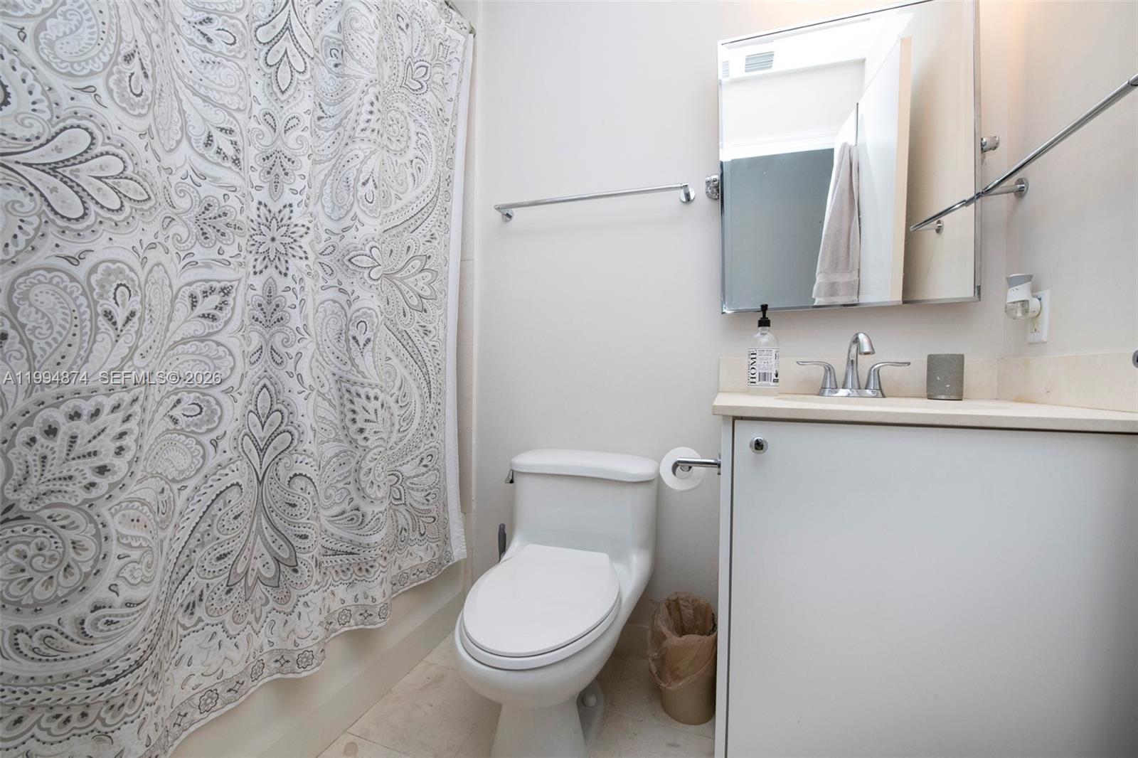 60 Southwest 13th Street, Unit 2820 Miami, FL 33130 - Photo 10 of 25 a bathroom with a toilet sink and mirror