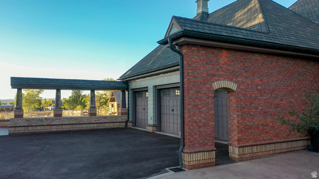 426 West Center Street Parowan, UT 84761 - Photo 90 of 107 Brick exterior with a dark roofline, featuring two garage doors and an arched entry