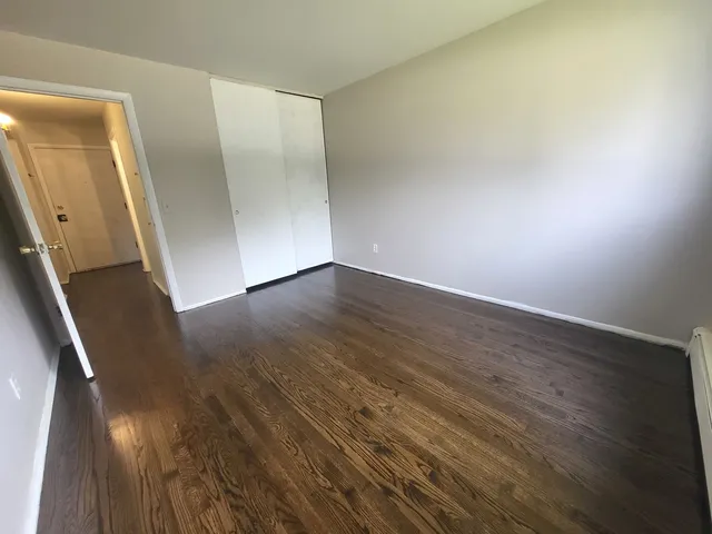 an empty room with wooden floor and entrance