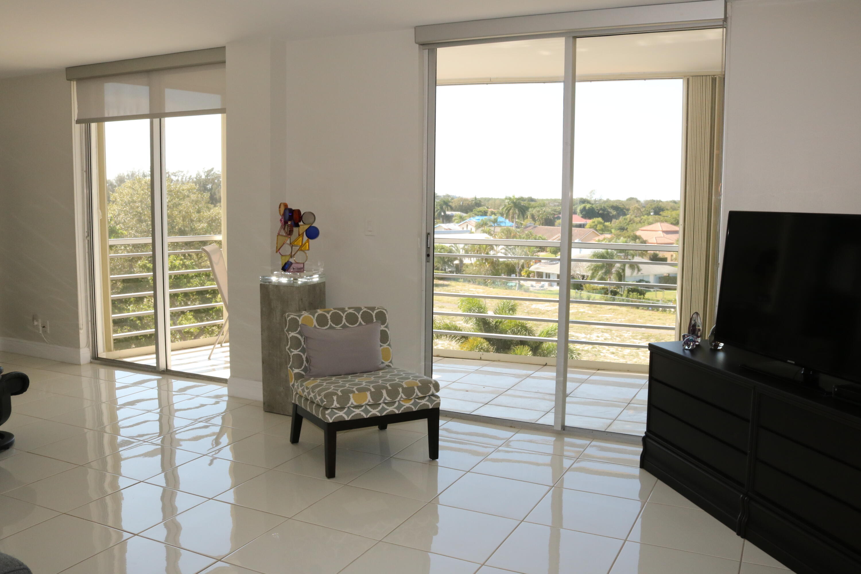 6461 Northwest 2nd Avenue, Unit 508 Boca Raton, FL 33487 - Photo 20 of 39 a living room with furniture and a flat screen tv