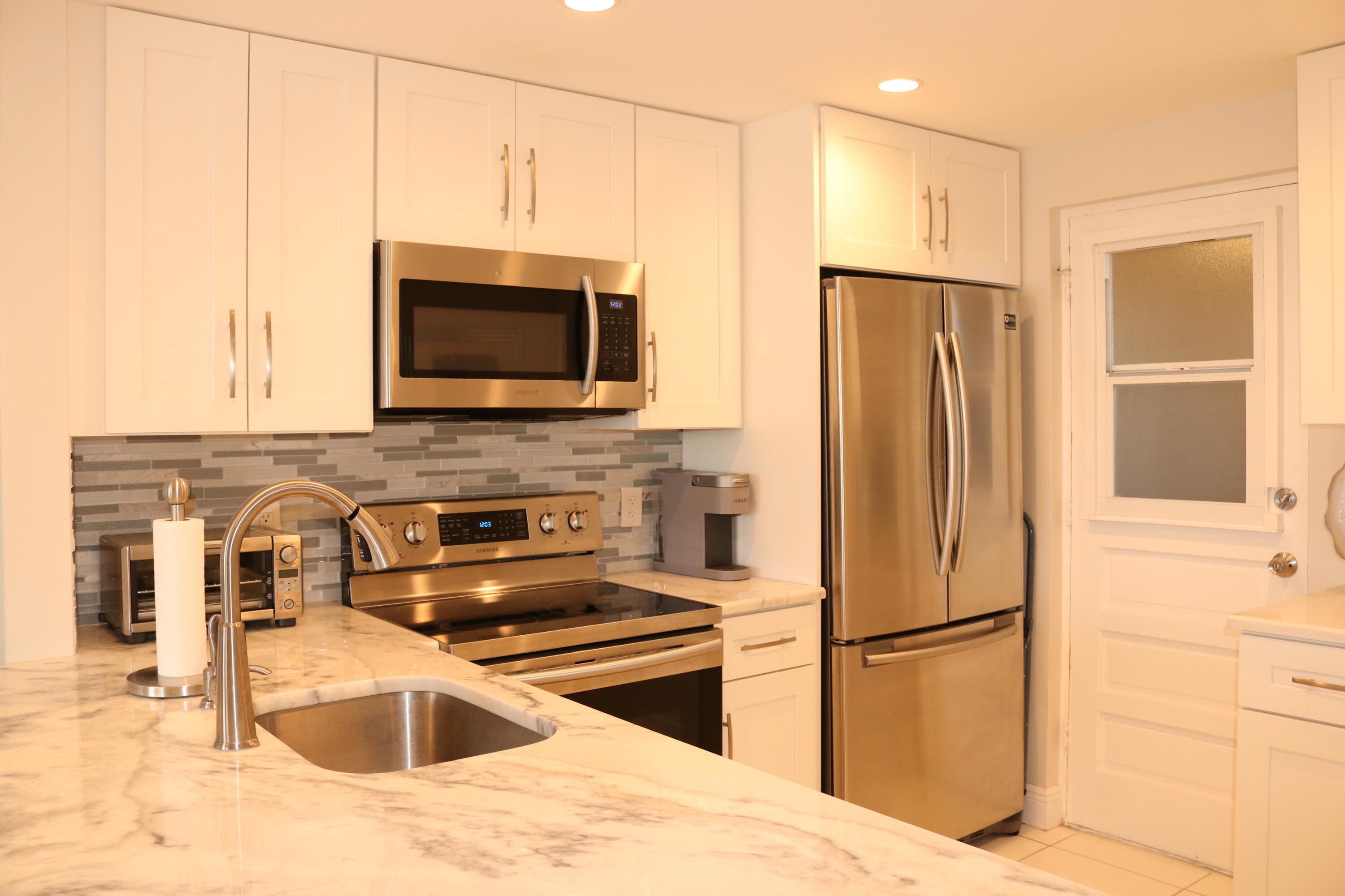 6461 Northwest 2nd Avenue, Unit 508 Boca Raton, FL 33487 - Photo 4 of 39 a kitchen with stainless steel appliances granite countertop a refrigerator and a sink