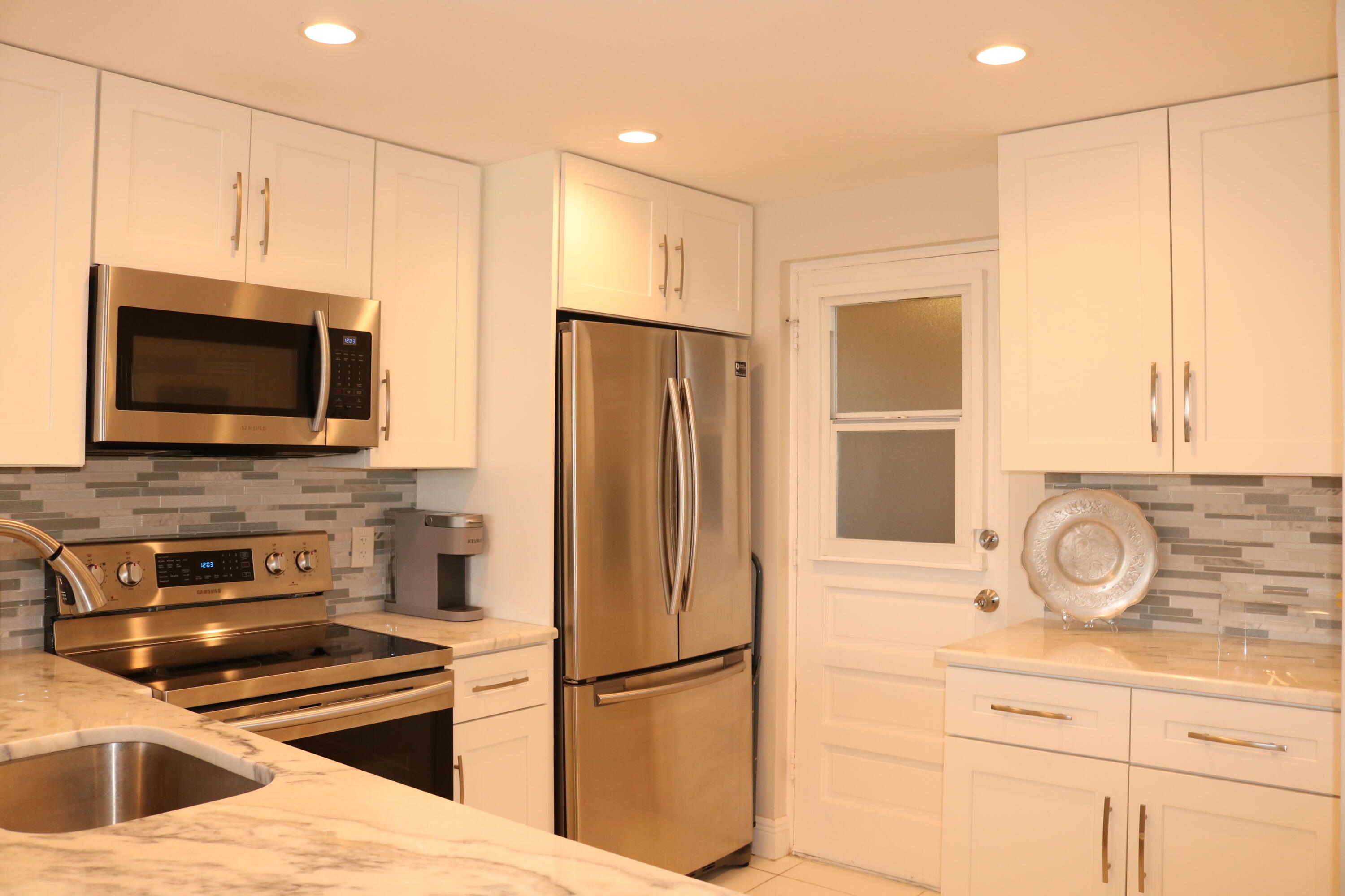 6461 Northwest 2nd Avenue, Unit 508 Boca Raton, FL 33487 - Photo 5 of 39 a kitchen with a refrigerator and a stove top oven