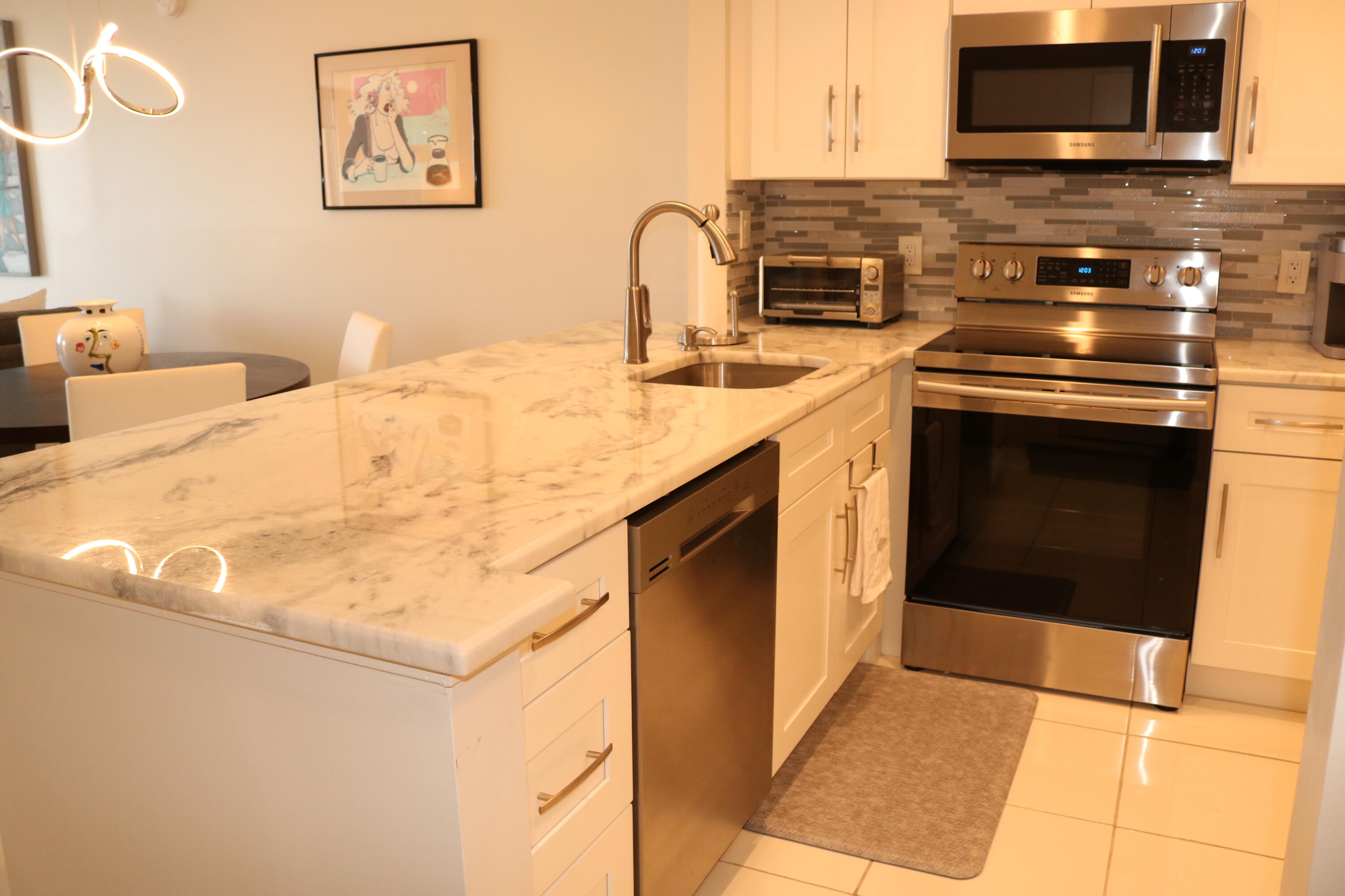 6461 Northwest 2nd Avenue, Unit 508 Boca Raton, FL 33487 - Photo 8 of 39 a kitchen with stainless steel appliances granite countertop a stove a sink and a microwave