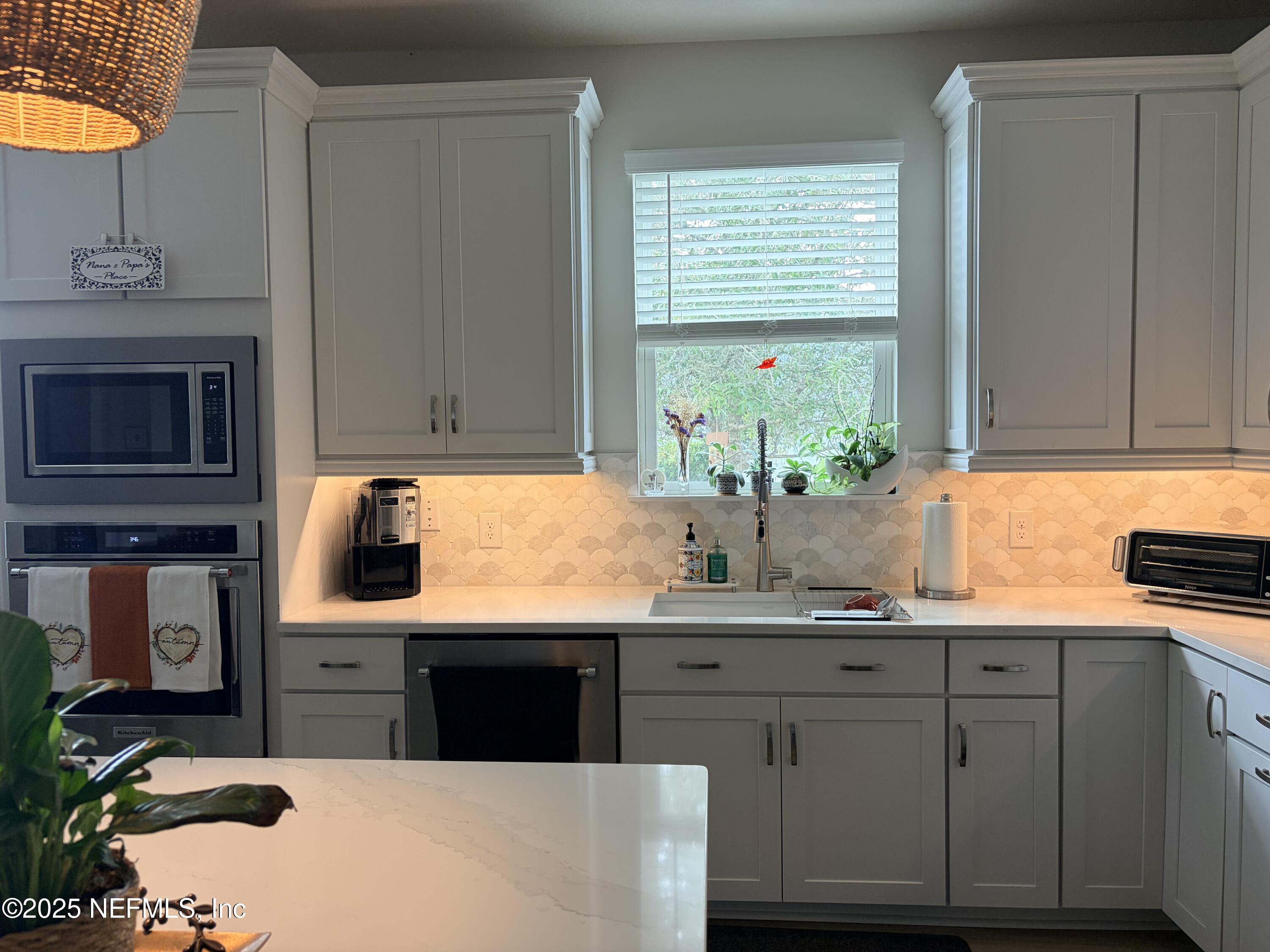 22 Myrtle Oak Court St. Augustine, FL 32092 - Photo 11 of 36 a kitchen with kitchen island granite countertop a sink cabinets and window
