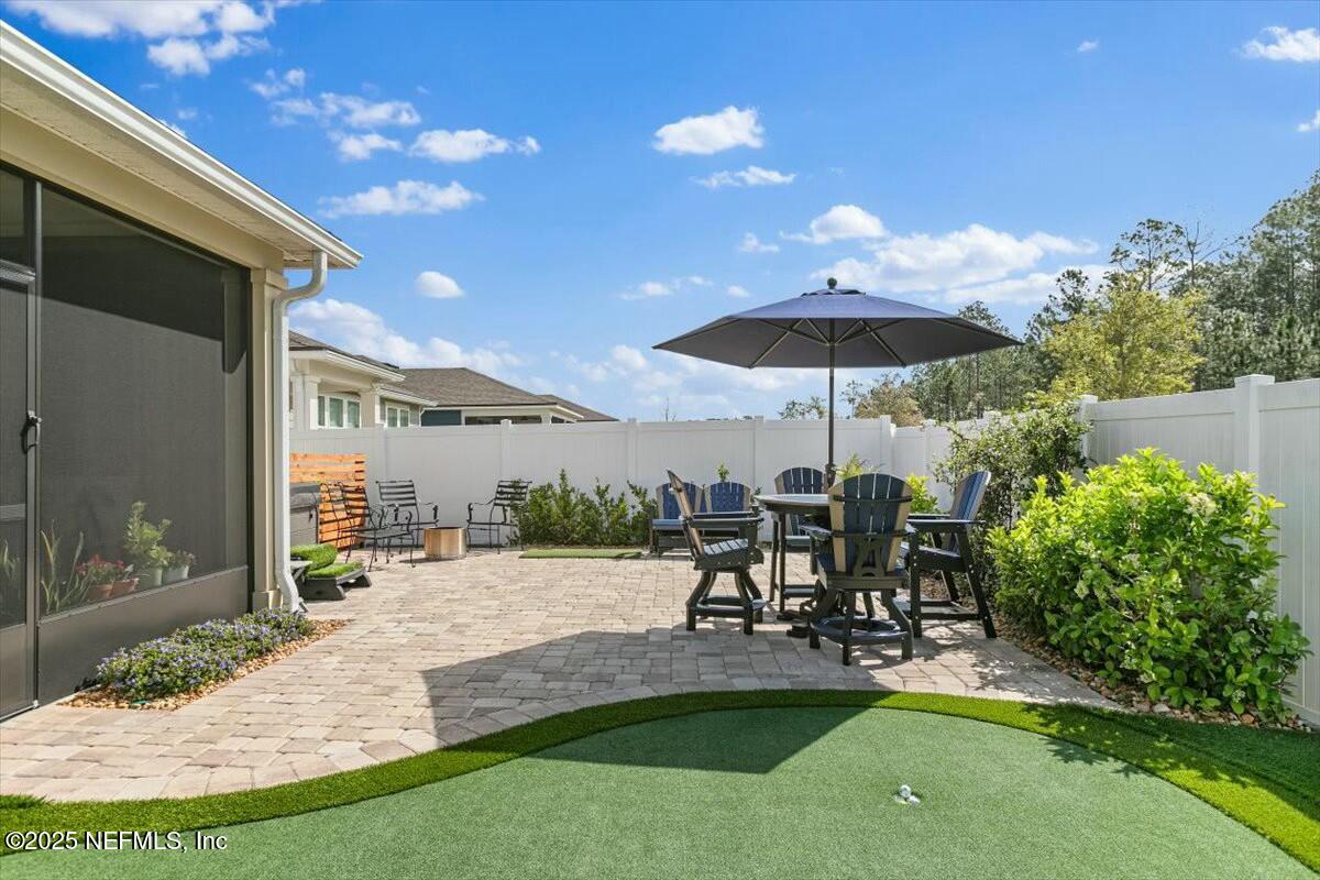22 Myrtle Oak Court St. Augustine, FL 32092 - Photo 28 of 36 a view of a patio with table and chairs under an umbrella