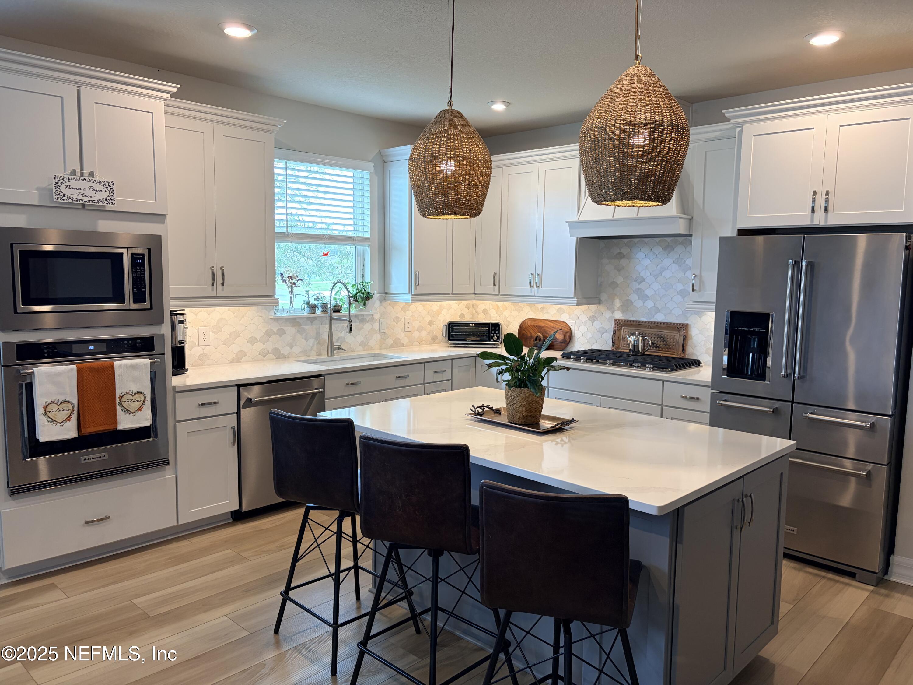 22 Myrtle Oak Court St. Augustine, FL 32092 - Photo 8 of 36 a kitchen with stainless steel appliances granite countertop a sink a stove a refrigerator a dining table and chairs