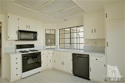 880 Congressional Road Simi Valley, CA 93065 - Photo 8 of 19 a kitchen with granite countertop white cabinets and black stainless steel appliances