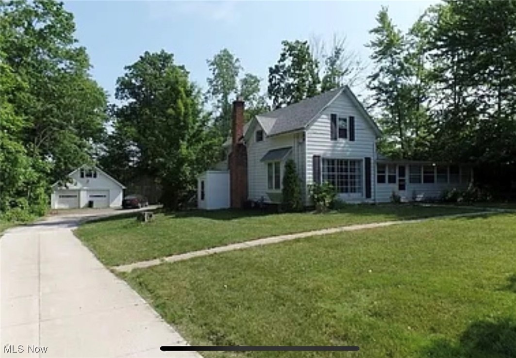 Front facade featuring a front yard and a garage