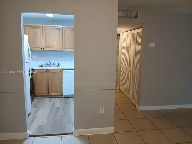 a view of a kitchen with wooden floor and a sink
