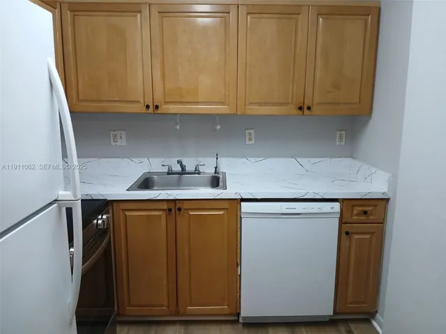 a kitchen with stainless steel appliances granite countertop wooden cabinets and a sink
