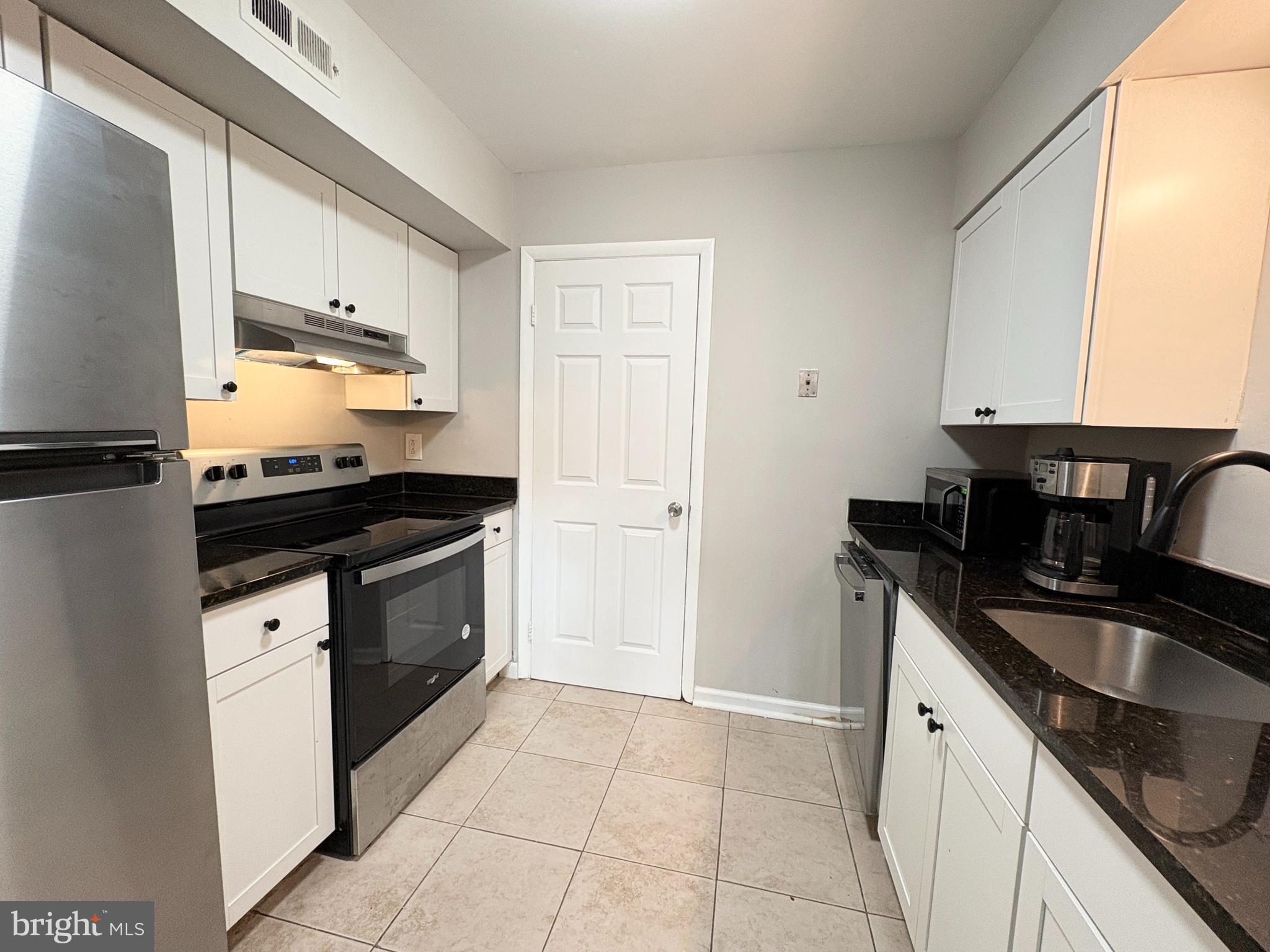 3813 Segundo Place, Unit D Alexandria, VA 22309 - Photo 3 of 28 a kitchen with granite countertop a sink stove and cabinets