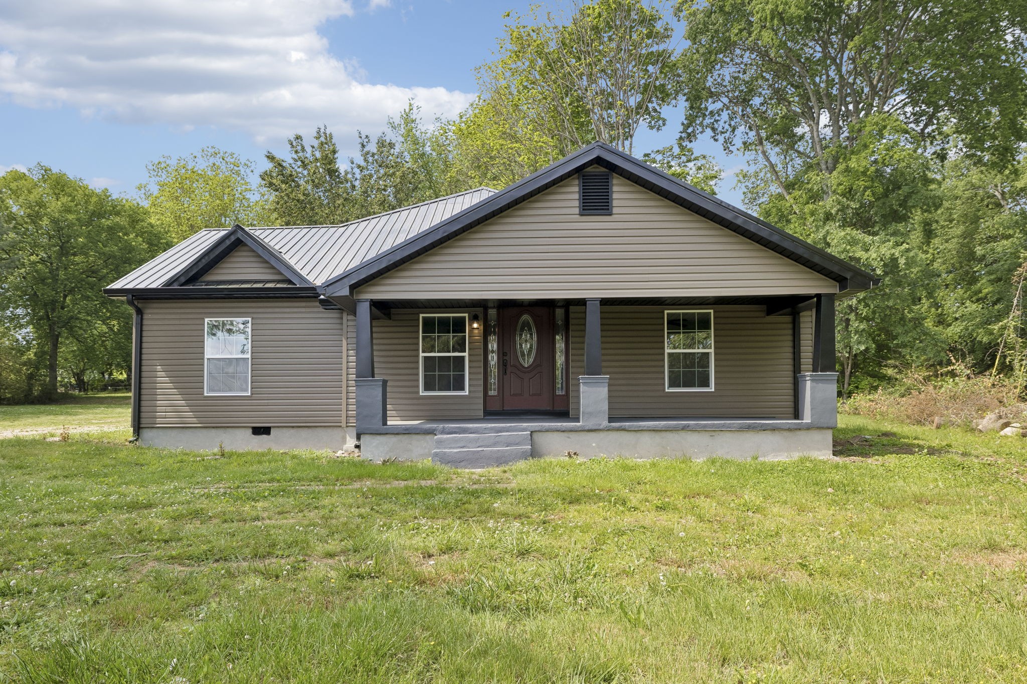 a front view of a house with yard and green space