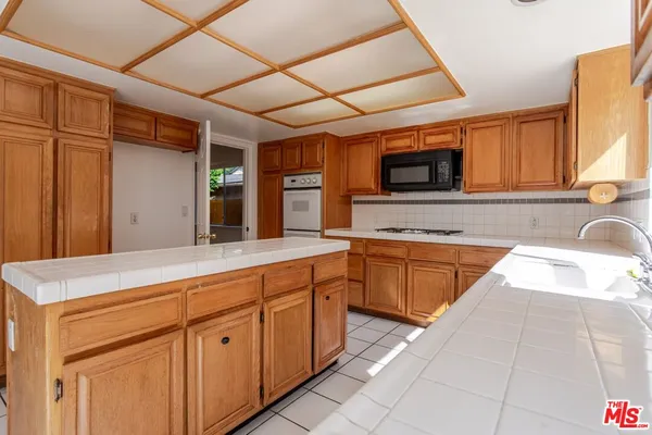 a kitchen with granite countertop cabinets stainless steel appliances and a sink