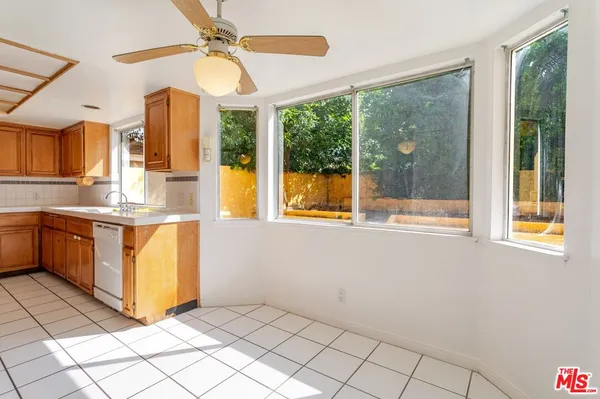 a kitchen with a sink window and cabinets