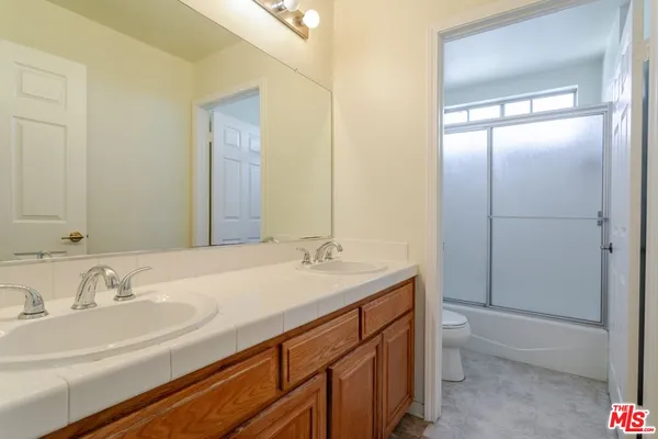 a bathroom with a tub a sink and mirror
