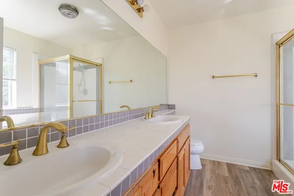 a bathroom with a sink a toilet and a mirror