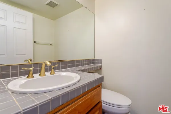 a bathroom with a sink toilet and mirror