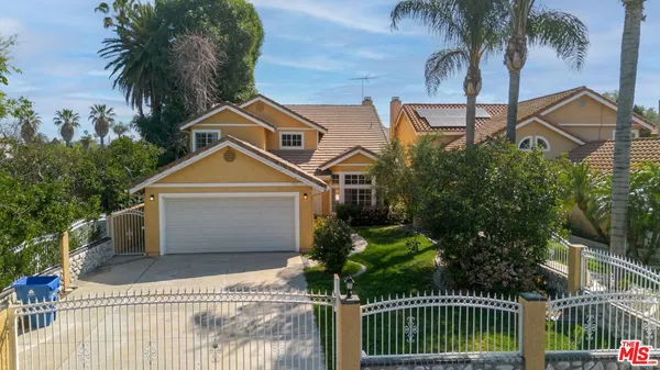 a view of a white house with a yard and potted plants