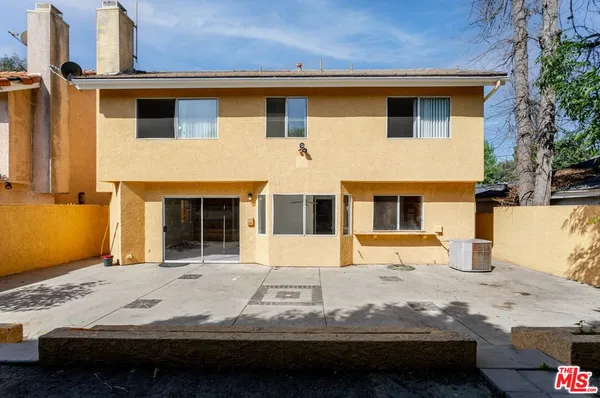 a view of a house with a wooden fence