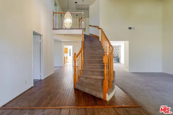 a view of a hallway with wooden floor and staircase