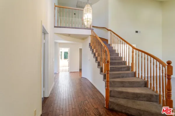 a view of a hallway with wooden floor and entryway