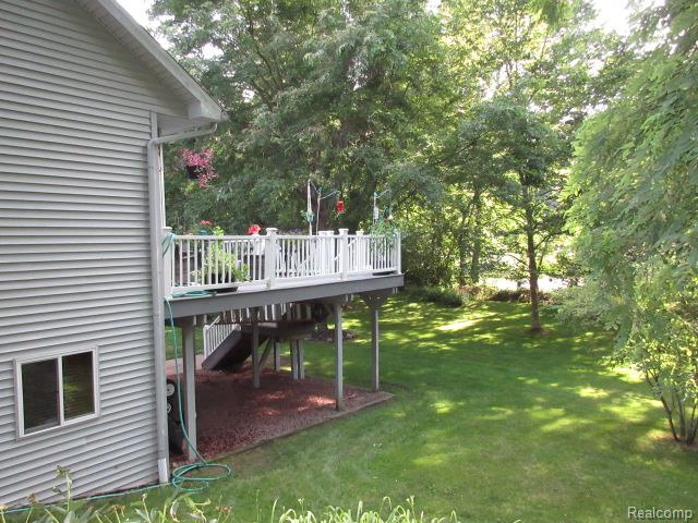 11356 Tall Shadows Court Pinckney, MI 48169 - Photo 8 of 29 Elevated outdoor deck with white railings overlooking a spacious green lawn