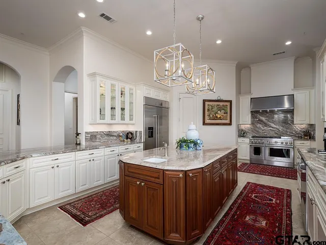 a large kitchen with kitchen island a sink stove and wooden cabinets