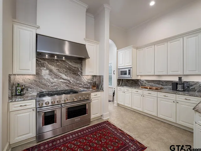 a kitchen with granite countertop a stove top oven sink and cabinets